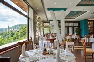大特尔诺沃扬特拉大酒店的餐厅设有桌椅和大窗户。