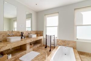 弗朗斯胡克La Terra de Luc的浴室配有两个盥洗盆和浴缸。