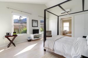 弗朗斯胡克La Terra de Luc的白色的卧室设有一张大床和一个窗户