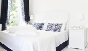 阿格罗波利帕拉左多加纳度假酒店的一张带蓝色枕头的白色床和窗户