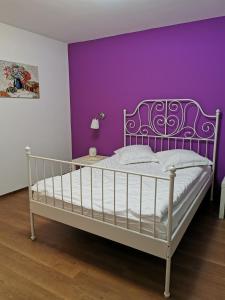 布拉索夫Drumul Poienii Apartment的卧室配有白色床和紫色墙壁