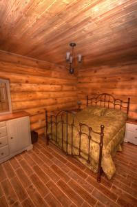 Saint-Tite-des-Caps圆木流度假屋的小木屋内一间卧室,配有一张床