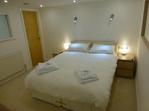 克鲁厄尔之家服务式公寓的卧室配有带毛巾的大型白色床