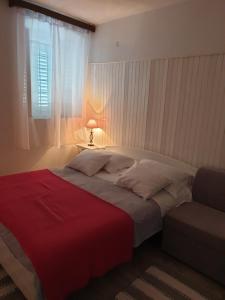 德雷斯Apartments Neda的一间卧室配有一张带红色毯子的床和窗户。