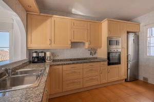 贝纳尔马德纳Tio Charles的厨房配有木制橱柜和不锈钢用具