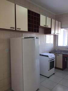 拉热斯Apto em ótima localização!的厨房配有白色橱柜和冰箱。