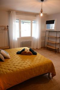 罗纳河畔的图尔农L'Oiseau Bleu的一间卧室配有一张带黄色床罩的床和窗户
