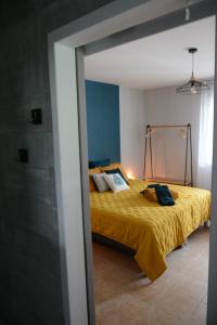 罗纳河畔的图尔农L'Oiseau Bleu的一间卧室配有一张黄色床罩的床