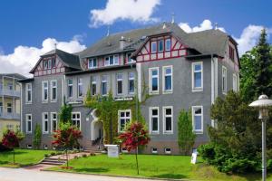 奥斯特西巴德钦诺维茨Vineta Strandhotels的一座大型灰色建筑,有红色屋顶