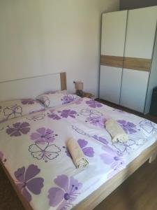 斯顿Apartments Ivanka的一间卧室,床上有紫色鲜花