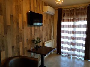 卢戈日pensiunea grecu的客厅配有桌子和墙上的电视