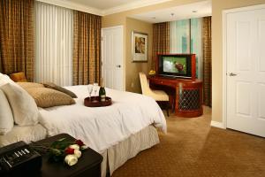 拉斯维加斯签名豪华套房国际酒店的酒店客房,配有床和电视
