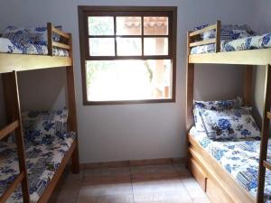 彼得罗波利斯Casa de campo的客房设有两张双层床和一扇窗户。