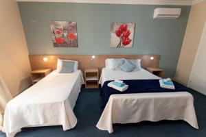 拉巴特Estrella Lodging的酒店客房,设有两张床,墙上挂着鲜花。