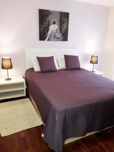 丰沙尔Apartamento Capela的一间卧室配有一张大床和两盏灯
