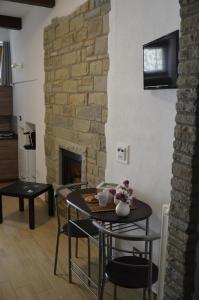 皮耶特拉佩尔托萨B&B La Casa Sulla Roccia的客厅配有桌椅和壁炉