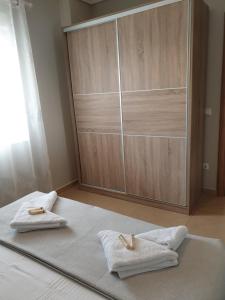 雅伊奥斯马马斯Villas Mamas Beach的一间卧室,在床上配有2条毛巾,配有衣柜