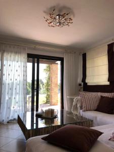 希维利3 Bedroom Villa in Elani Villas Chalkidiki的带沙发和玻璃桌的客厅