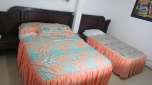 巴耶杜帕尔Hotel Nuevo Tio的一间卧室配有两张带橙色棉被的床
