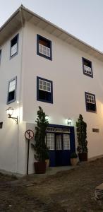 欧鲁普雷图Casa dos Meninos B&B的白色的建筑,设有蓝色的门窗