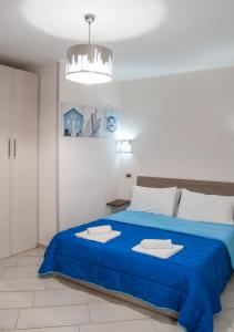 锡拉库扎Casa Euripide的一间卧室配有蓝色的床和吊灯。