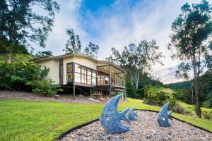Palm Grove幽静雨林度假酒店的前面有两座鱼雕像的房子
