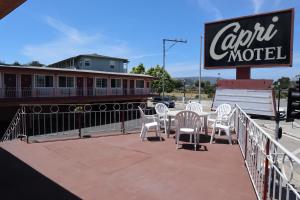 圣克鲁兹Capri Motel Santa Cruz Beach Boardwalk的一间咖啡厅,里面设有白色的椅子、标志和火车