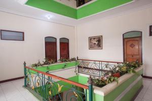 泗水RedDoorz @ Genteng Surabaya 2的客房设有带绿色和白色墙壁的楼梯。