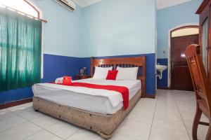 泗水RedDoorz @ Genteng Surabaya 2的一间卧室配有一张带红色毯子的大床
