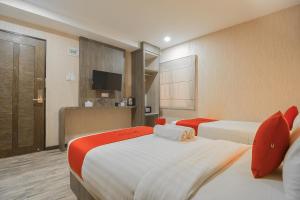 名古屋Paragon Nagoya Hotel Batam的酒店客房设有两张床和电视。