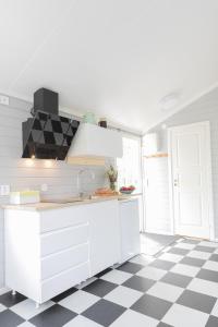 乌拉勒德Gunnagård的白色厨房,铺有黑白的格子地板
