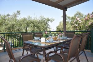 凯里翁Olivella Villas by Vatos的露台的桌椅,甲板上种有树木
