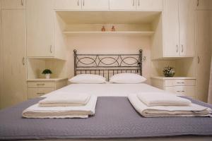 科孚镇Beautiful Corfu City Apartment的一间卧室配有一张床,上面有两条毛巾