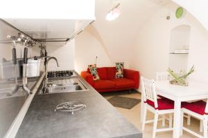 基耶蒂B&B Teate的一间厨房和一间带红色沙发的客厅