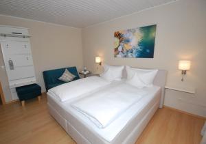 赖因伯伦斗兽场旅馆的卧室配有白色的床和蓝色椅子