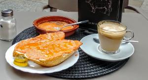 马拉加马拉加城市公寓的包括烤面包的早餐和一杯咖啡的餐桌