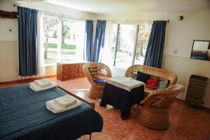 胡宁德洛斯安第斯奇梅惠恩旅馆的一间卧室设有两张床、椅子和窗户。