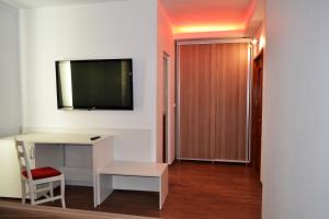 皮特什蒂Hotel Rehoma的一间房间,配有一张桌子和一台墙上的电视