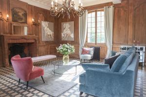 勒纽伯格Le manoir des chevaux dorés的客厅配有蓝色椅子和壁炉