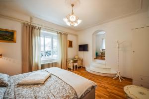 卢布尔雅那Kavon Apartments的一间卧室设有一张床、一个窗户和一个吊灯。