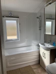 罗斯伯里Riverside Rothbury Superior Lodge的带淋浴、浴缸和盥洗盆的浴室