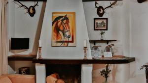 埃尔罗西奥Hospedarte Arenas de El Rocio的客厅设有壁炉,配有马画