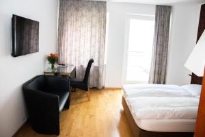 杜塞尔多夫斯特恩酒店的卧室配有1张床、1张桌子和1把椅子