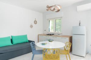 马蒂纳塔Residence TerraBella的带沙发、桌子和冰箱的客厅