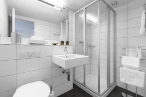 科尔斯腾鲍姆加滕酒店的白色的浴室设有水槽和镜子
