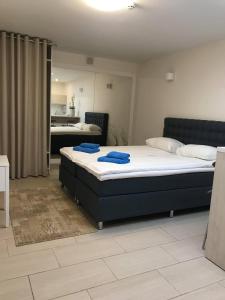 帕兰加Home of Health and Beauty的一间卧室配有两张床和蓝色毛巾。