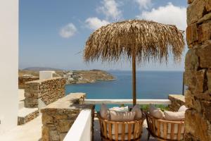 凯勒里瓦迪The Summit of Mykonos的一个带椅子和遮阳伞的庭院和大海