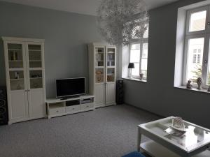 施特雷利茨Apartment im Herzen von Neustrelitz的客厅配有平面电视和2扇窗户。