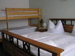 SeelowWaldhotel Seelow的卧室配有2张双层床和白色床单
