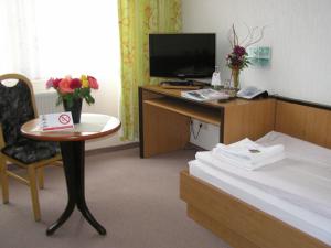 SeelowWaldhotel Seelow的酒店客房配有书桌和床。